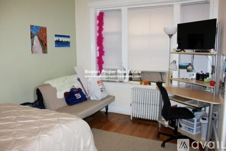 A bedroom with a bed, desk, and chair.