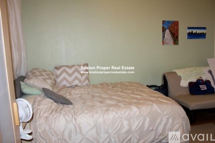 A bedroom with a bed and a bench with a New York Giants pillow.