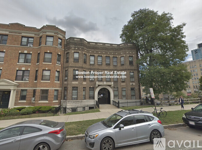 A street view of a building with the text "Boston Proper Real Estate" on it.
