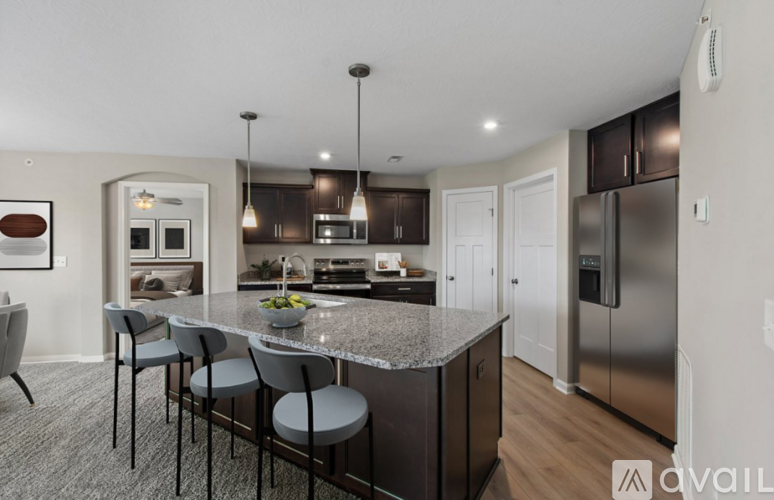 A kitchen with a granite countertop and stainless steel appliances.