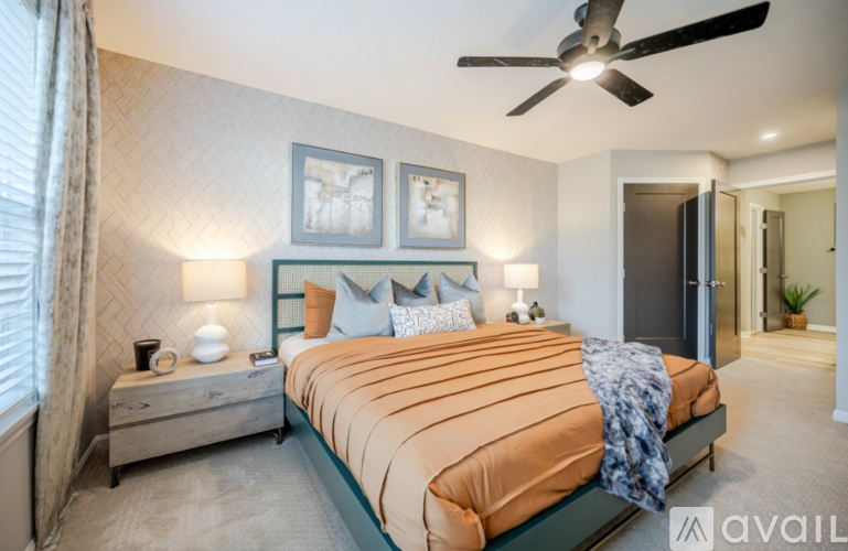 A bedroom with a large bed and a ceiling fan.