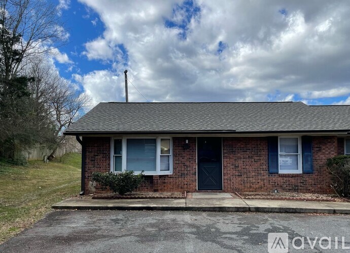 A house with a grey roof and a blue door is for sale.