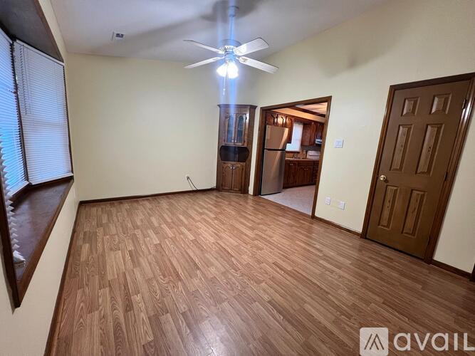 A room with wooden flooring and a ceiling fan.