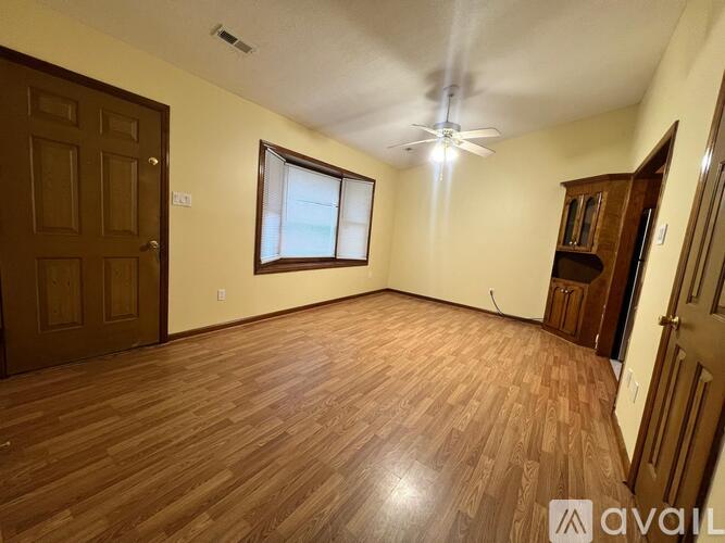 A room with wooden flooring and a ceiling fan.