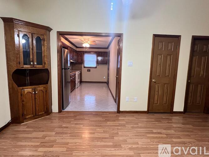A room with wooden floors and a TV mounted on the wall.