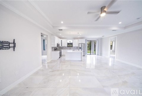 A room with a marble floor and a window showing trees outside.