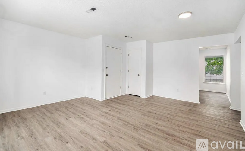 A room with a white wall and a wooden floor.