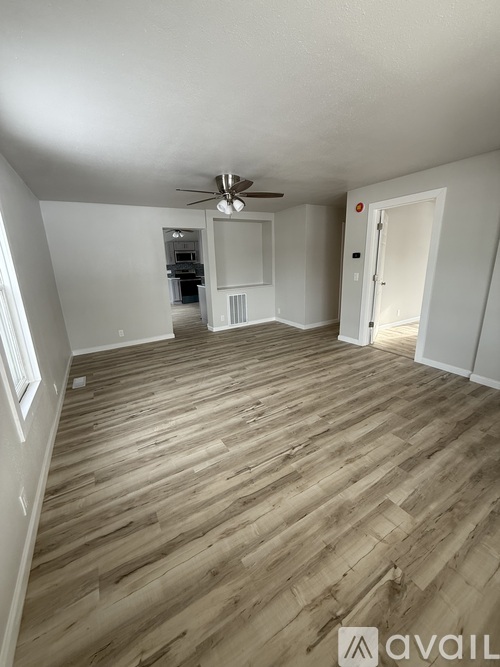 A room with wooden flooring and a ceiling fan.