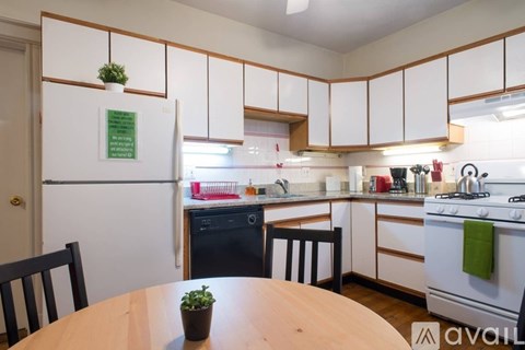 A kitchen with a table and chairs in front of it.
