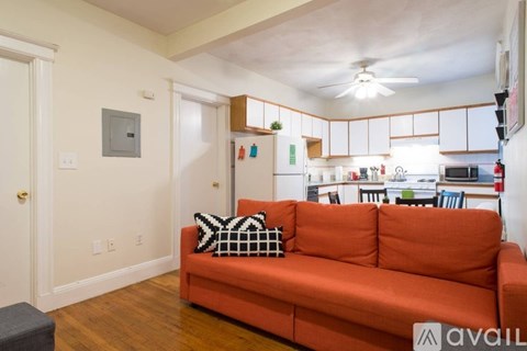 A living room with a red couch and a ceiling fan.