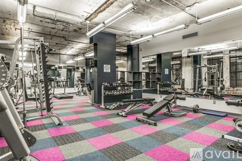 A gym with a variety of equipment including treadmills, weights, and exercise machines.