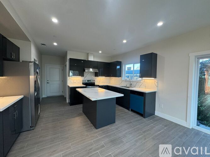 A modern kitchen with a refrigerator, sink, and cabinets.