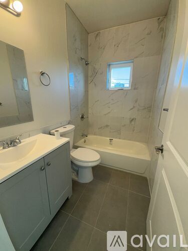 A bathroom with a marble wall and a toilet.
