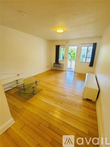 A long hallway with a bench on the left and a door on the right.