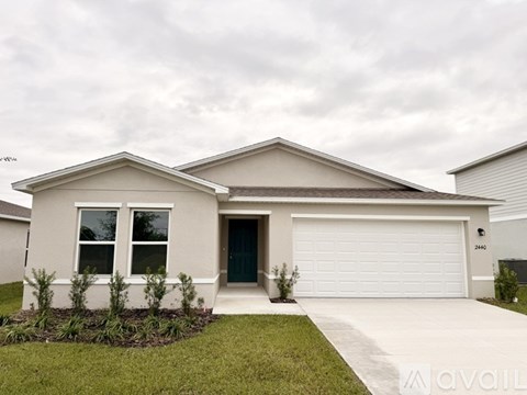 A two-story house with a garage and a driveway.