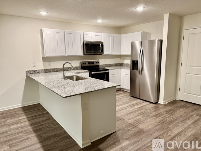 A kitchen with a granite countertop and stainless steel appliances.