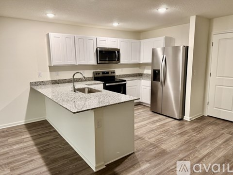 A kitchen with a granite countertop and stainless steel appliances.