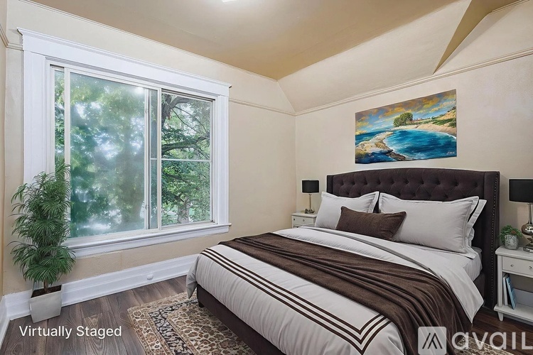 A bedroom with a large bed and a painting on the wall.