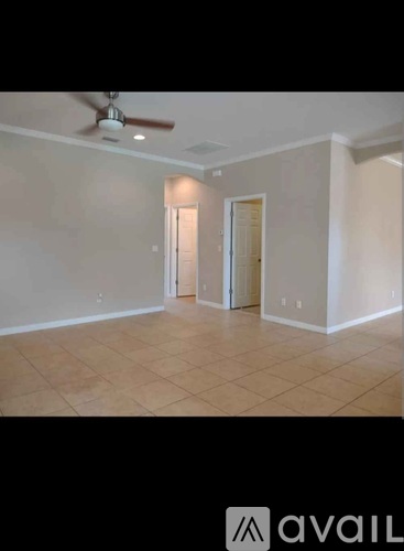 A room with a ceiling fan and two doors.