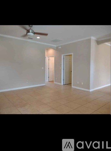 A room with a ceiling fan and two doors.