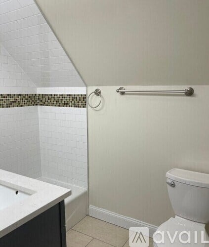 A white toilet sits next to a white sink in a bathroom.