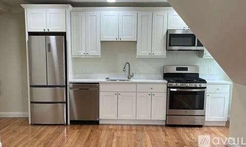 A kitchen with white cabinets and stainless steel appliances.