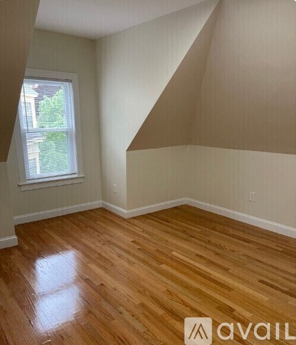 A room with wooden flooring and a window.