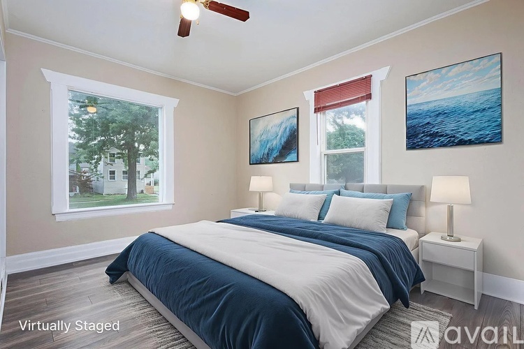 A bedroom with a bed, two lamps, and two pictures on the wall.