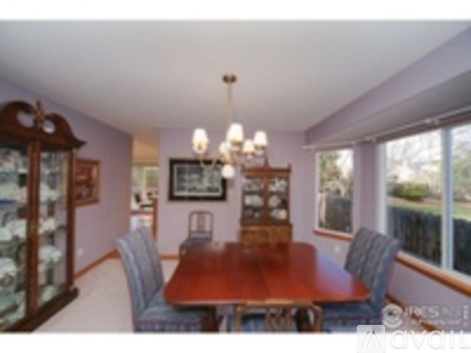A dining room with a wooden table and chairs.