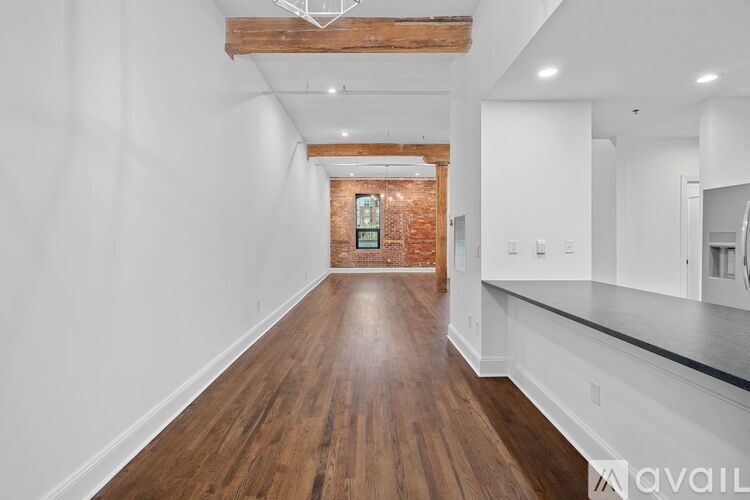 A long hallway with wooden floors and white walls.