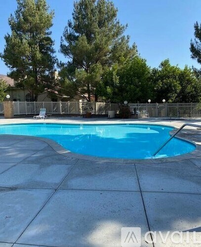 A pool surrounded by a fence and trees.