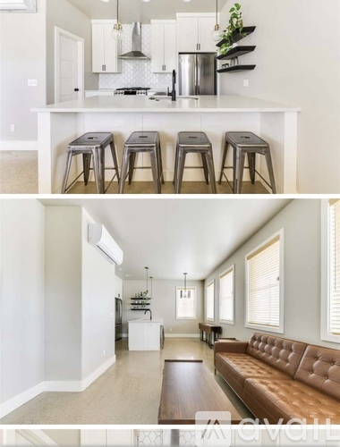 A modern kitchen with white cabinets and a bar area with stools.