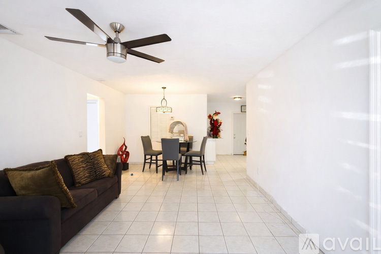 A living room with a brown couch and a ceiling fan.