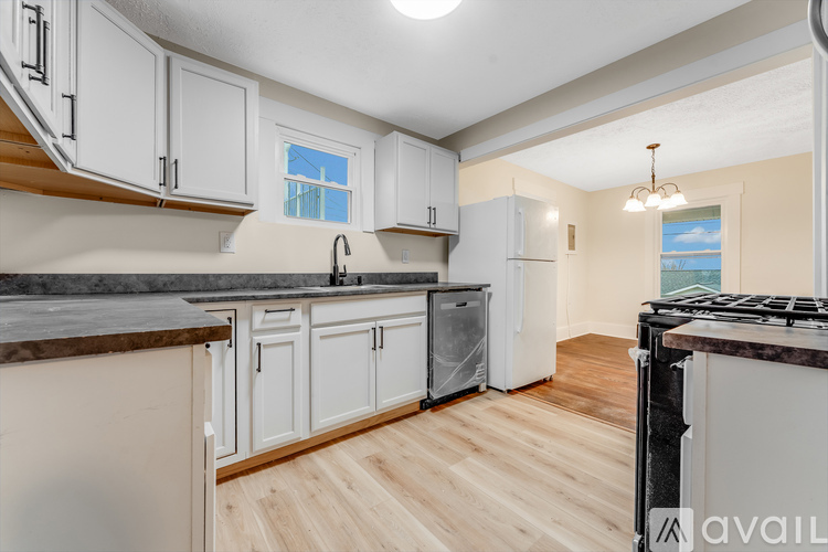 A kitchen with white cabinets and a black stove top oven.