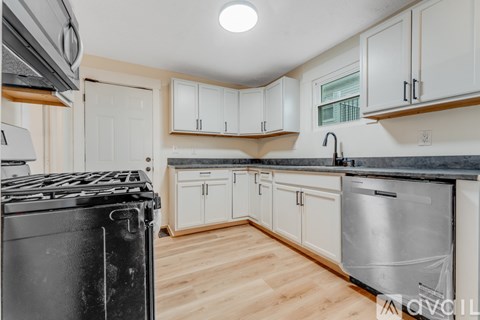 A kitchen with white cabinets and a black stove top.