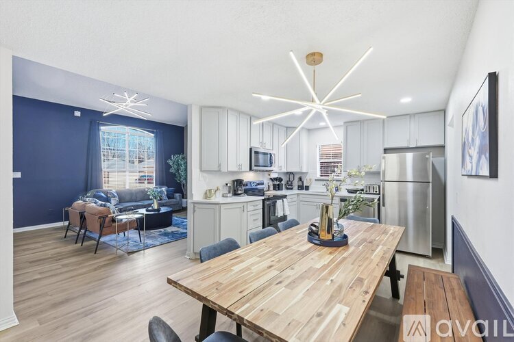 A modern kitchen with a wooden dining table and chairs.