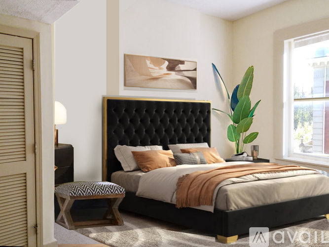 A bedroom with a large bed and a painting on the wall.