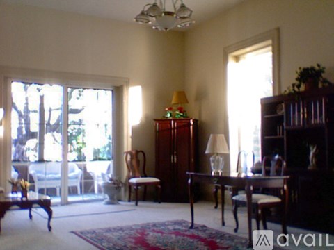 A living room with a table, chairs, and a cabinet.
