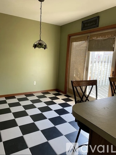 A room with a checkered floor and a hanging light fixture.