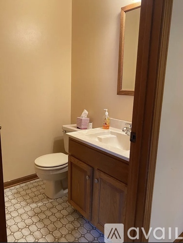 A bathroom with a toilet, sink, and mirror.
