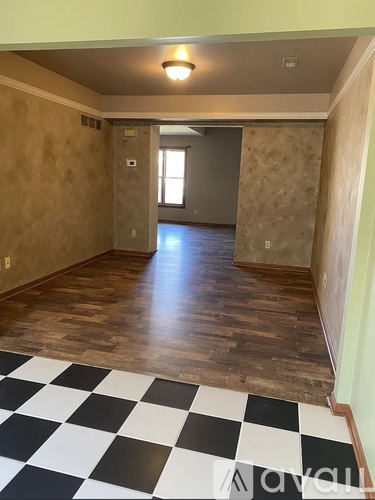 A room with a checkered floor and wooden walls.