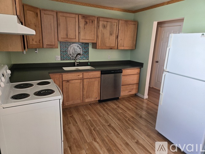 A kitchen with a white stove and wooden cabinets.