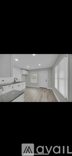 A modern kitchen with white cabinets and a granite countertop.