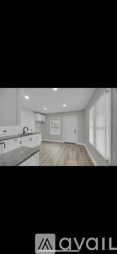 A modern kitchen with white cabinets and a granite countertop.