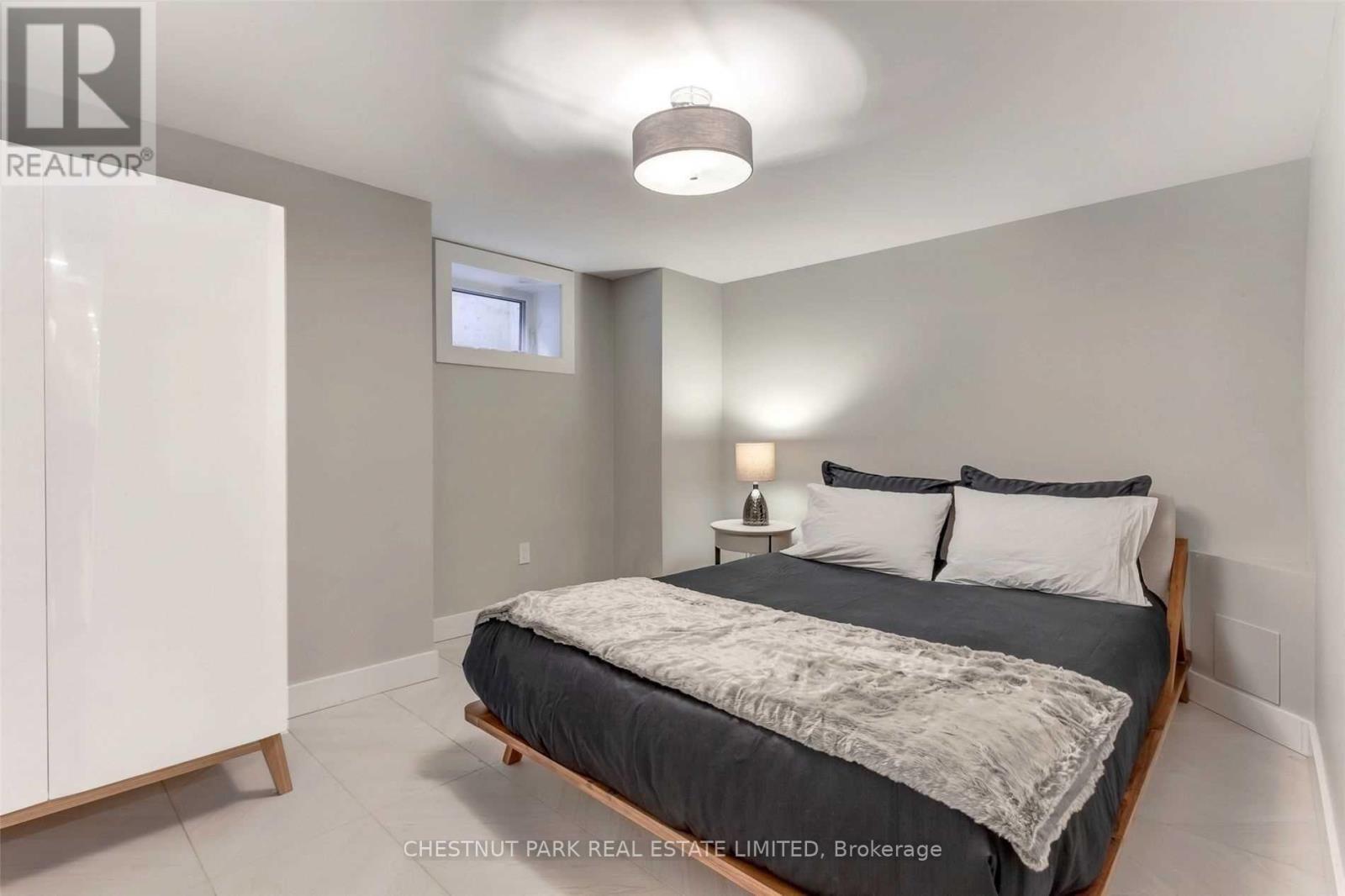 A bedroom with a bed, nightstand, and lamp.