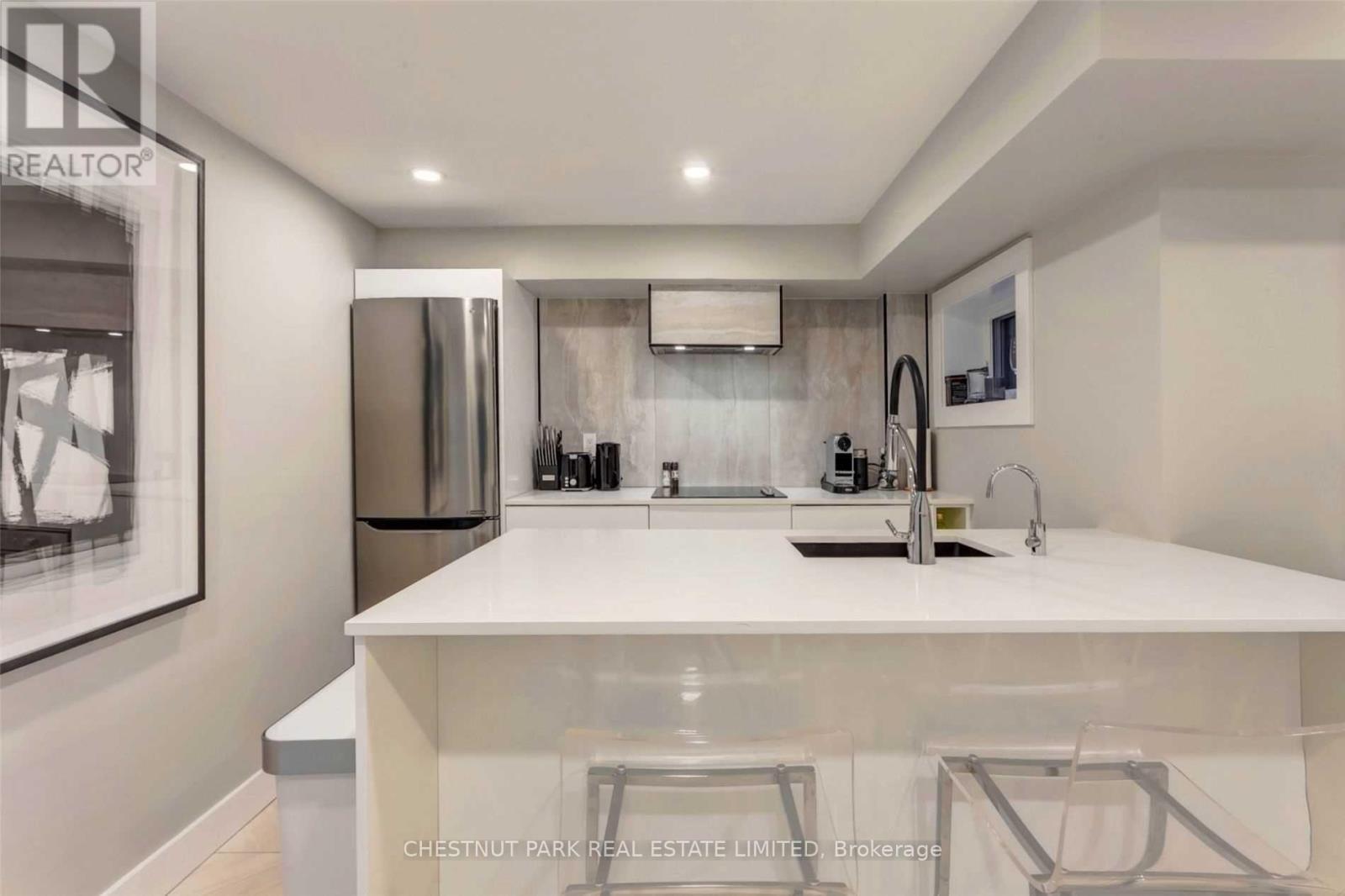 A modern kitchen with a white countertop and stainless steel appliances.