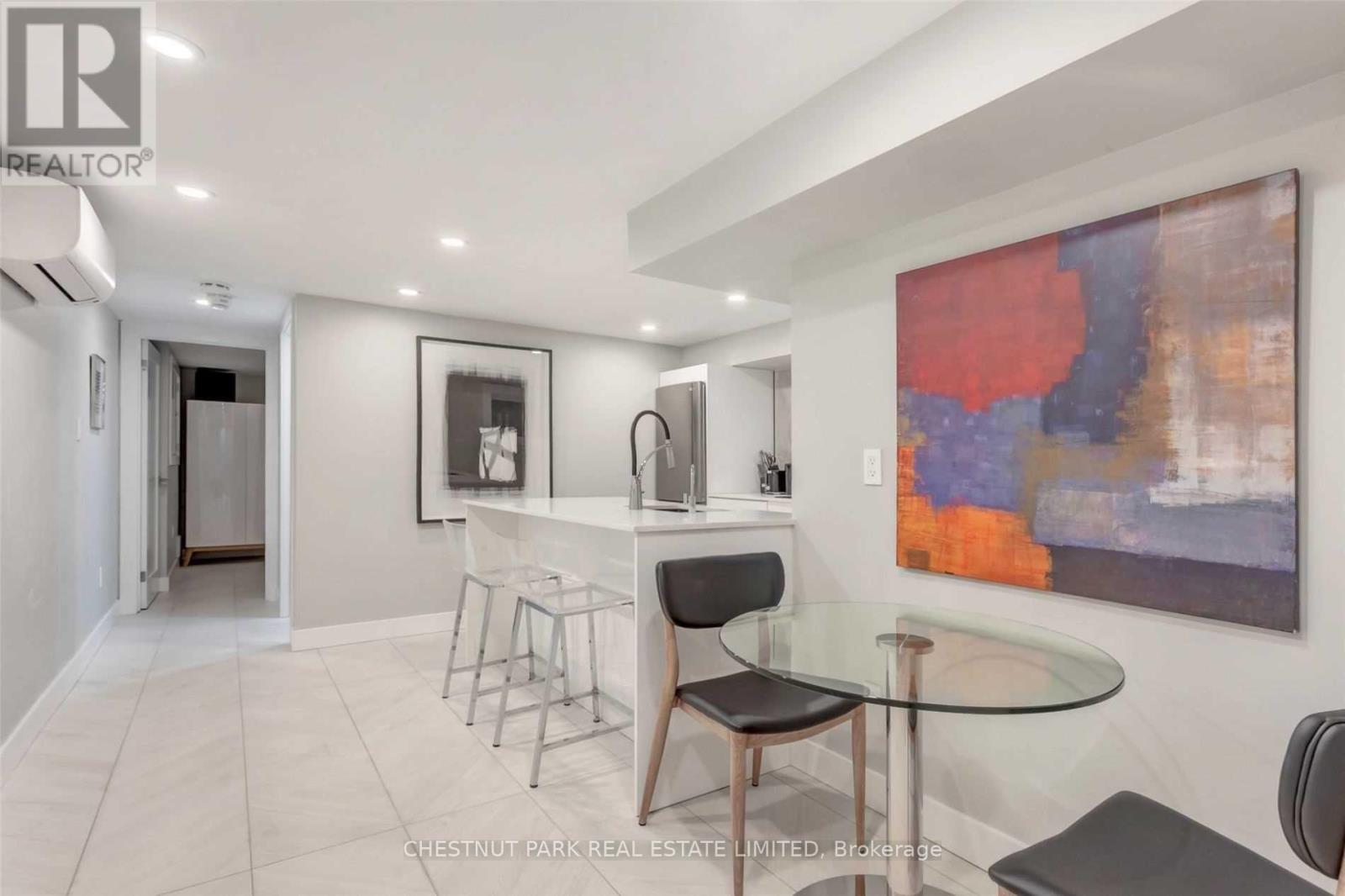 A modern dining room with a glass table and chairs.