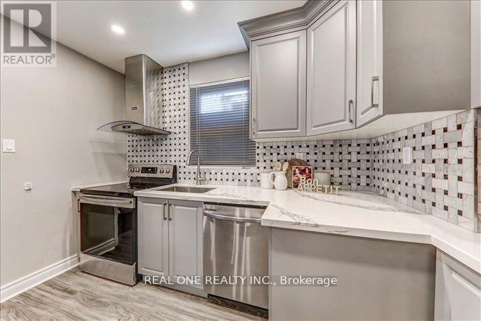 A kitchen with a stainless steel oven and white cabinets.
