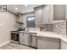 A kitchen with a stainless steel oven and white cabinets.