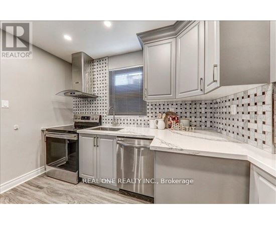 A kitchen with a stainless steel oven and white cabinets.